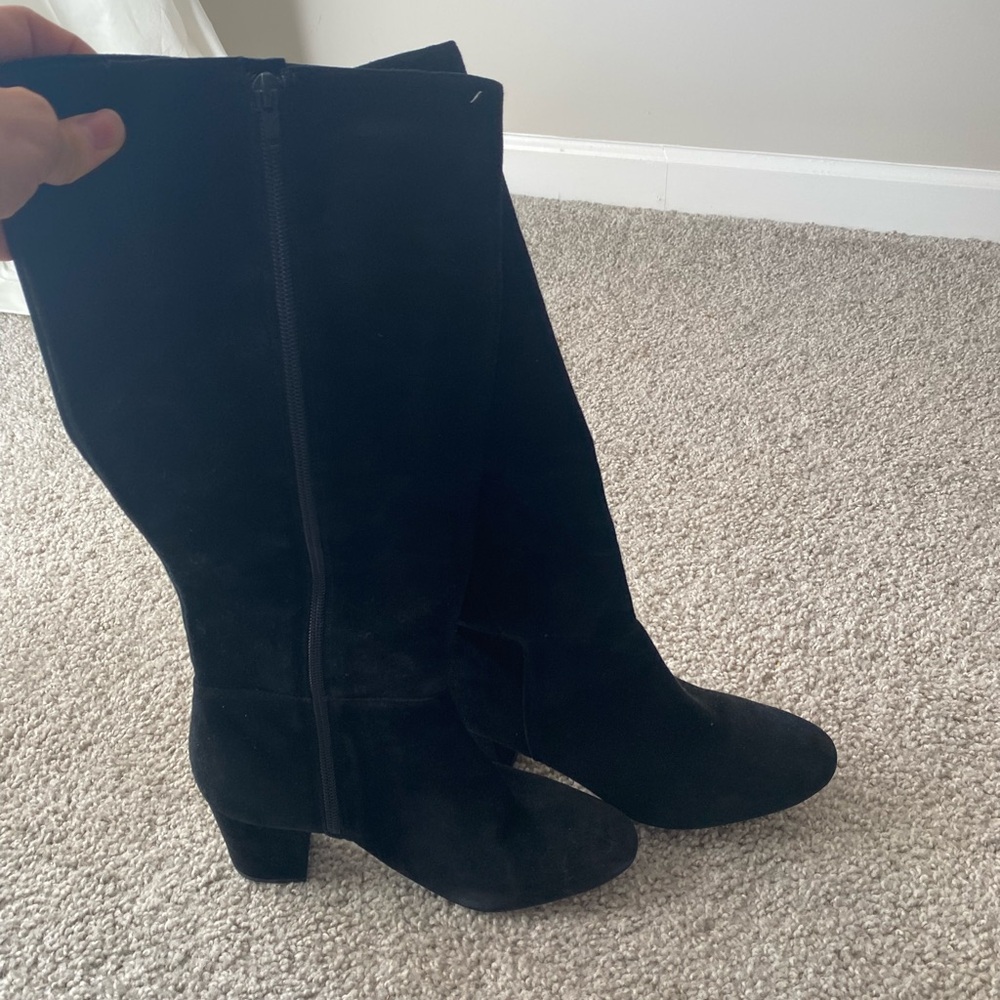 Knee high black suede boots.